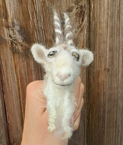 A goat finger puppet made from felt.